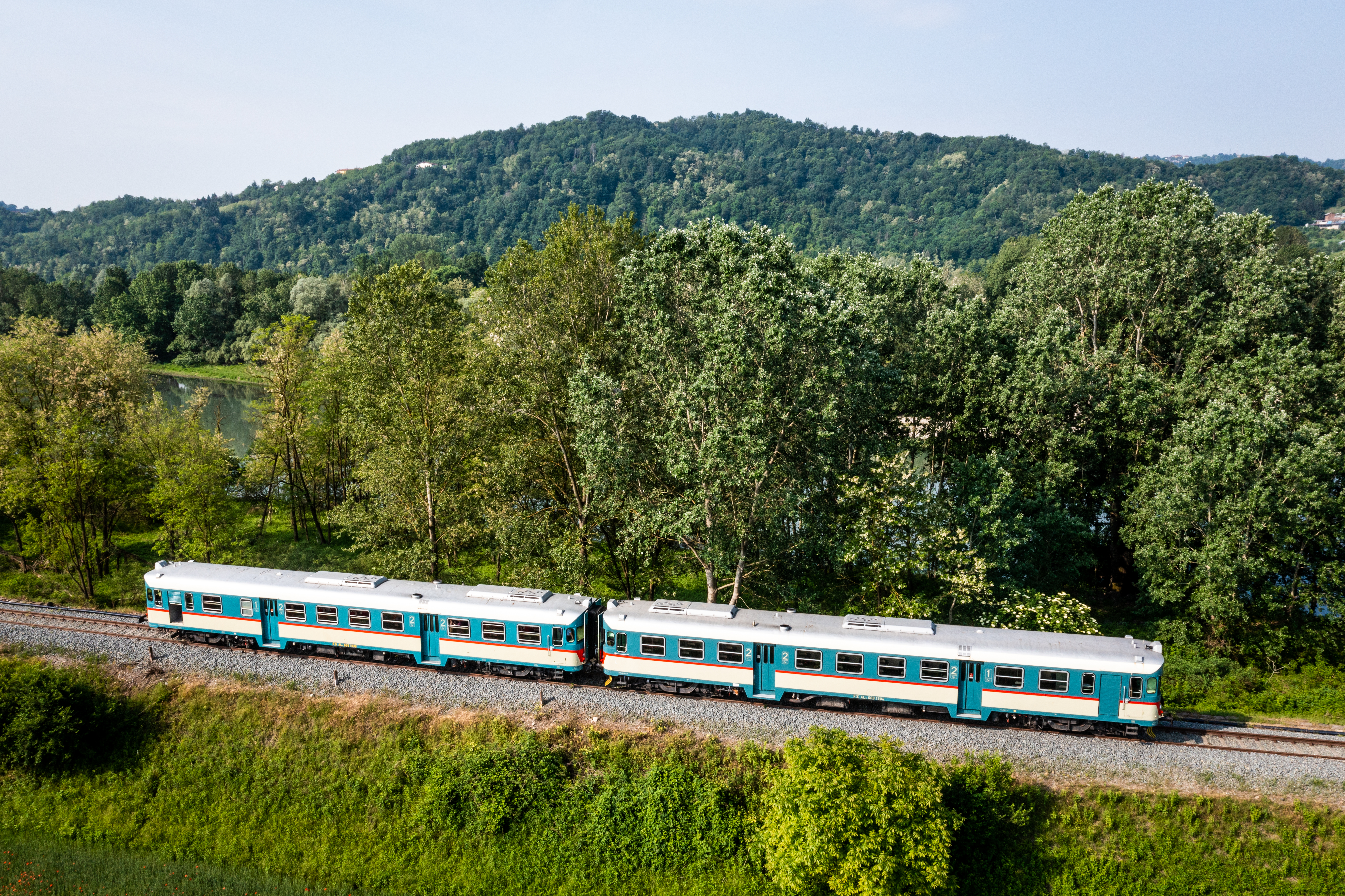 A vintage train passing through the scenic Piemonte region, offering a nostalgic view of historic rail travel.